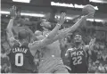  ??  ?? Raptors forward Kawhi Leonard (center) drives to the basket in the first quarter against the Suns at Talking Stick Resort Arena on Friday.