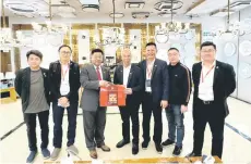  ?? ?? Frankie Liew presents Sabah specialty coffee to He Yifeng, witnessed by chairman Chiew Heng Hock and members of SCCC Young Entreprene­urs.