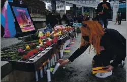  ??  ?? Jackie Brookins leaves a candle at a vigil for Natalia Smüt in front of San Jose City Hall on Saturday. “She was amazing,” a longtime friend said of the drag artist.