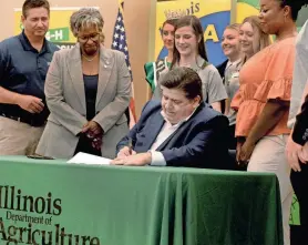  ?? THOMAS J. TURNEY/STATE JOURNAL-REGISTER ?? Illinois Gov. JB Pritzker signs a bill Aug. 14 that provides Future Farmer’s of America or 4-H students excused absents for program related events.