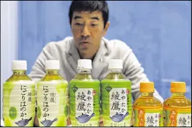  ??  ?? Takashi Wasa, senior vice president at Coca-Cola Japan, shows “Ayataka” at Tokyo headquarte­rs. The green tea is among 20 CocaCola global brands that bring in $1 billion or more in annual sales.