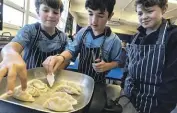  ?? ?? Jacob Vega Grant, left, Benjamin Savoian and Blaze Ruscoe learn how to make dumplings.