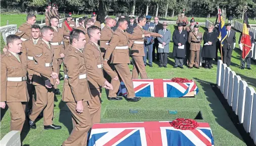  ??  ?? FULL MILITARY HONOURS: Soldiers prepare to bury two coffins during the service at Wytschaete Military Cemetery, near Ypres, yesterday