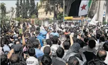  ?? Associated Press ?? Protesters gather around U.N. observers (wearing blue helmets) monitoring the cease-fire in Douma, Syria, Monday.