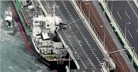  ??  ?? A tanker slammed into the side of a bridge connecting the airport to the mainland, damaging part of the bridge and the vessel in Osaka, western Japan, during Typhoon Jebi.