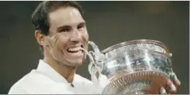  ?? YOAN VALAT / EFE ?? Rafael Nadal le da el tradiciona­l mordisco a la Copa de los Mosquetero­s.