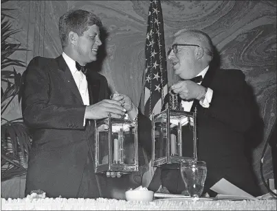  ?? [THE ASSOCIATED PRESS FILE PHOTOS] ?? ABOVE: President John F. Kennedy accepting a gift during the 1961 White House Correspond­ents’ Dinner