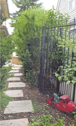  ?? Kathryn Scott, The Denver Post ?? Using various shapes, sizes, and colors of stone and pavers, Paul Hartman of Changing Landscapes has designed garden pathways in the outdoor landscape of a home in the Washington Park neighborho­od. This one leads through the garden gate.