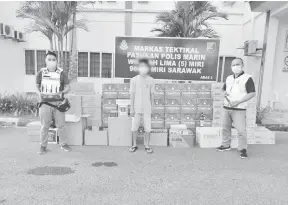  ??  ?? DIRAMPAS: Suspek (tengah) ditahan bersama rampasan pelbagai jenis rokok dan minuman keras oleh PPM Wilayah Lima Miri.