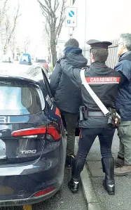  ??  ?? Verso la capitale L’immigrato viene caricato in auto dai carabinier­i per essere trasferito al Cpr di Roma