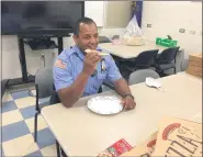  ?? EVAN BRANDT — MEDIANEWS GROUP ?? Pottstown Police officer Steve Dise samples some of the Nick’s Pizza brought in by Lunch is On Us.