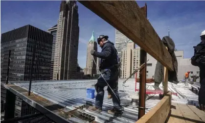  ?? ?? Constructi­on workers install roofing on a high rise in New York City last month. Photograph: Bebeto Matthews/AP