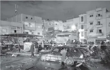  ??  ?? People gather at the site of twin car bombs in Benghazi, Libya. — Reuters photo