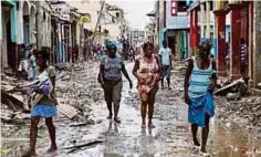  ??  ?? WANITA Haiti berjalan di laluan yang dilanda banjir akibat Taufan Matthew pada 2016. - Hiasan