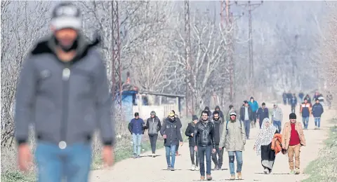  ?? REUTERS ?? Migrants walk between Pazarkule border crossing and Karaagac district near the Turkish-Greek border in Edirne, Turkey yesterday.