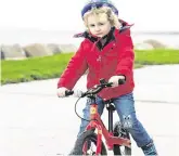  ??  ?? Carefree: Cian Hardiman (4), from Knocknacar­ra, Co Galway, goes for a cycle in the calm ahead of the storm in Salthill