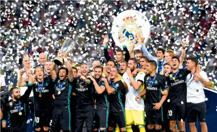  ??  ?? Real Madrid players celebrate with the trophy after winning the Uefa Super Cup final against Manchester United at the Philip II Arena in Skopje on Tuesday. Real won 2-1. —