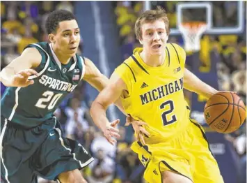  ?? RICK OSENTOSKI, USA TODAY SPORTS ?? Travis Trice chases Michigan’s Spike Albrecht on Sunday, when Michigan State could have used injured defensive stalwart Branden Dawson. The Spartans lost 79-70.