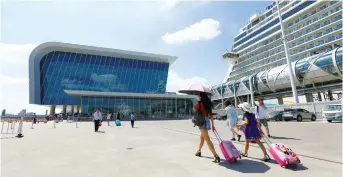  ??  ?? Passengers head to take the Norwegian Joy cruise, one of the three luxury cruise ships berthed at the new Wusongkou terminal on July 13. — Jiang Xiaowei