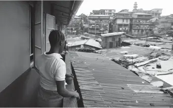  ??  ?? Kadiatu, 19, looks out over the slum of Susan’s Bay. — Reuters