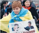  ?? Photo: REUTERS ?? A woman wrapped in a Ukrainian national flag carries a poster with portraits of Ukrainian army pilot Nadia Savchenko, left, and Kremlin critic Boris Nemtsov during a march to commemorat­e Nemtsov, who was shot dead in central Moscow in March this year.