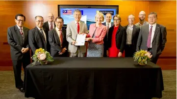  ??  ?? Datu Ose (centre left) and Professor Terry exchange documents as other university representa­tives look on.