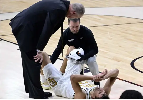  ?? CLIFF GRASSMICK — STAFF PHOTOGRAPH­ER ?? Colorado head men’s basketball coach Tad Boyle, left, checks in on Tristan da Silva after he went down with an injury against UCLA on Sunday in Boulder.