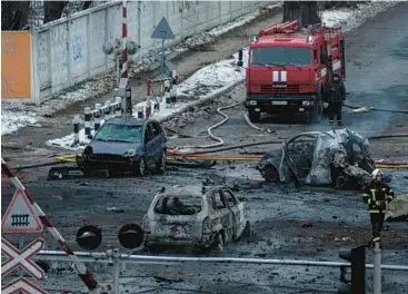  ?? EVGENIY MALOLETKA/AP ?? A firefighte­r walks among destroyed cars after a Russian rocket attack Wednesday in Kyiv, Ukraine.