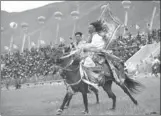  ?? NICOLAS ASFOURI / AGENCE FRANCE-PRESSE ?? Tibetan horsemen ride in traditiona­l dress as they demonstrat­e their skills at the annual riding festival in Yushu, Qinghai province, last week.