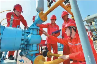  ?? TONG JIANG / FOR CHINA DAILY ?? Technician­s from Sinopec check oil storage facilities in Puyang, Henan province.