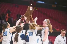  ?? BRIAN KRISTA/BALTIMORE SUN MEDIA ?? Howard players celebrate with their trophy after beating Poly in the Class 3A girls basketball state championsh­ip game Friday night at University of Maryland’s Xfinity Center in College Park.