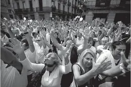  ?? Associated Press ?? People raise their hands on Saturday during a protest in favor of talks and dialogue in Sant Jaume square in Barcelona, Spain. Thousands gathered at simultaneo­us rallies in Madrid and Barcelona in a call for dialogue amid a political crisis caused by...