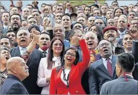  ?? [ARIANA CUBILLOS/THE ASSOCIATED PRESS] ?? Delcy Rodriguez, in red, the president of Venezuela’s Constituen­t Assembly, leads the newly sworn-in group as members pose for an official photo in front of the National Assembly in Caracas. The loyalist assembly is to rewrite the country’s...