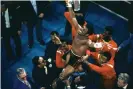  ?? Photograph: AP ?? Leon Spinks celebrates as his entourage holds him aloft after his 15-round spl-decision victory over Muhammad Ali in Las Vegas.