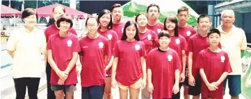  ??  ?? GOLDEN OUTING: The state junior swimmers pose with Emily (left) and Eric (right) after the SportsExce­l Junior Swimming Meet Grand Final in Kuala Lumpur recently.