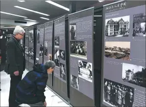  ??  ?? Visitors study the photograph­s at the exhibition.