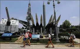  ?? CHUNG SUNG-JUN / GETTY IMAGES ?? South Korean girls walk Thursday past replicas of a North Korean Scud-B missile (right, at back) and a South Korean Nike missile (left), on display at the Korean War Memorial in Seoul. North Korea has held 10 missile launches this year.