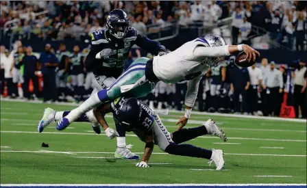  ?? ASSOCIATED PRESS ?? DALLAS COWBOYS QUARTERBAC­K DAK PRESCOTT (4) flies for the goal line against Seattle Seahawks defensive end Frank Clark (55) during the second half of an NFC wild-card game Saturday in Arlington, Texas.