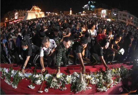  ?? — AFP photos ?? People lay down flowers at a vigil for victims following a deadly mass shooting in Nakhon Ratchasima.
