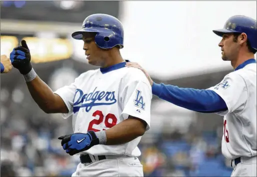  ?? CHRIS CARLSON / ASSOCIATED PRESS FILE ?? Adrian Beltre (left), then with the Dodgers, gets a pat on the back from Shawn Green after his three-run homer against the Angels during a game in 2003. Beltre has played for four teams since his debut in 1998.