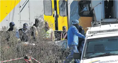  ?? / VELI NHLAPO ?? Police and a forensic team move the body of an unidentifi­ed man after two trains collided near the Elandsfont­ein station last year.