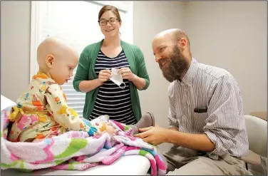  ?? NWA Democrat-Gazette/DAVID GOTTSCHALK ?? Ann Meythaler holds the mask of her daughter Hayden, 2, during their visit with Dr. Joel Frankhause­r, M.D., March 7 at the Direct Care Clinic of Northwest Arkansas in Rogers.