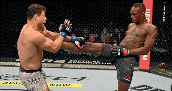  ?? GETTY IMAGES ?? New Zealand’s Israel Adesanya lands a kick to the throat of Paulo Costa during their middleweig­ht championsh­ip bout at UFC 253 on Fight Island.