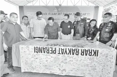  ??  ?? IKRAR: Sapawi serta tetamu kehormat yang lain menandatan­gani gegantung Ikrar Bebas Rasuah (IBR) pada majlis itu.
