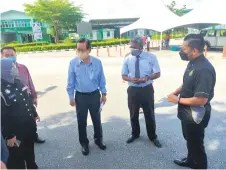  ?? ?? Lee (second left) talks to Immigratio­n officers and MDDMC members during the visit to Sungai Tujuh CIQS. On his left is Dr P Raviwharmm­an.