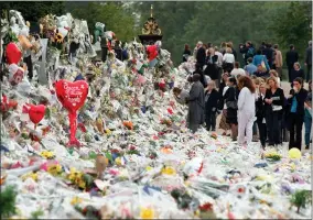  ?? AP PHOTO/DAVID BRAUCHLI, FILE ?? FILE - Mourners file past the tributes left in memory of Diana Princess of Wales at Kensington Palace in London, Friday, Sept. 5, 1997. It was a warm Saturday evening and journalist­s had gathered at a Paris restaurant to enjoy the last weekend of summer. At sometime past midnight, phones around the table began to ring all at once. News desks were contacting reporters and photograph­ers to alert them that Princess Diana’s car had crashed in the Pont de l’alma tunnel in Paris. That’s how the news unfolded in the early hours of Aug. 31, 1997.