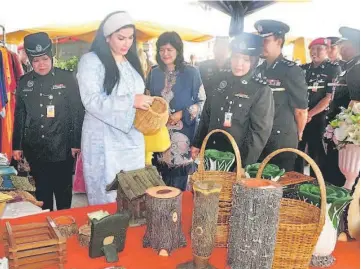  ??  ?? Ragad (second left) admiring the handicraft products made by inmates at the event.