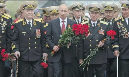  ?? A L E X E Y D RU Z H I N I N / A F P/ G E T T Y I MAG E S F I L E S ?? Russian President Vladimir Putin, centre, and Second World War veterans lay flowers at a war memorial during Putin’s visit to the Crimean port of Sevastopol last May.