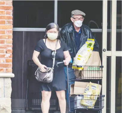  ?? PETER J THOMPSON/NATIONAL POST FILES ?? Grocery store patrons wear masks in Toronto during the COVID-19 pandemic in May. The growing food insecurity is because many Canadians have lost their jobs and most face a future of uncertaint­y, says Sylvain Charlebois.