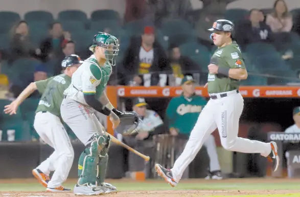  ?? ?? l Roberto Ramos anota una carrera para los Naranjeros, que lucieron su uniforme verde en honor al Ejército, Fuerza Aérea y Guardia Nacional.